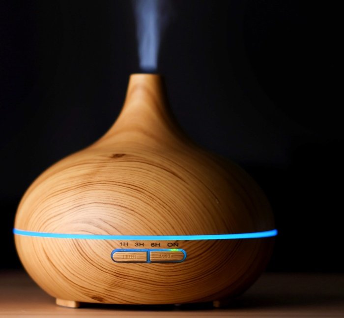 mental health wooden diffuser with blue light misting into the air  